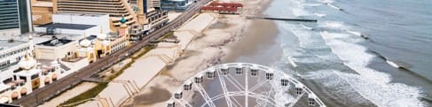 Waves break on a stretch of beach along Steel Pier. The city stretches beyond.